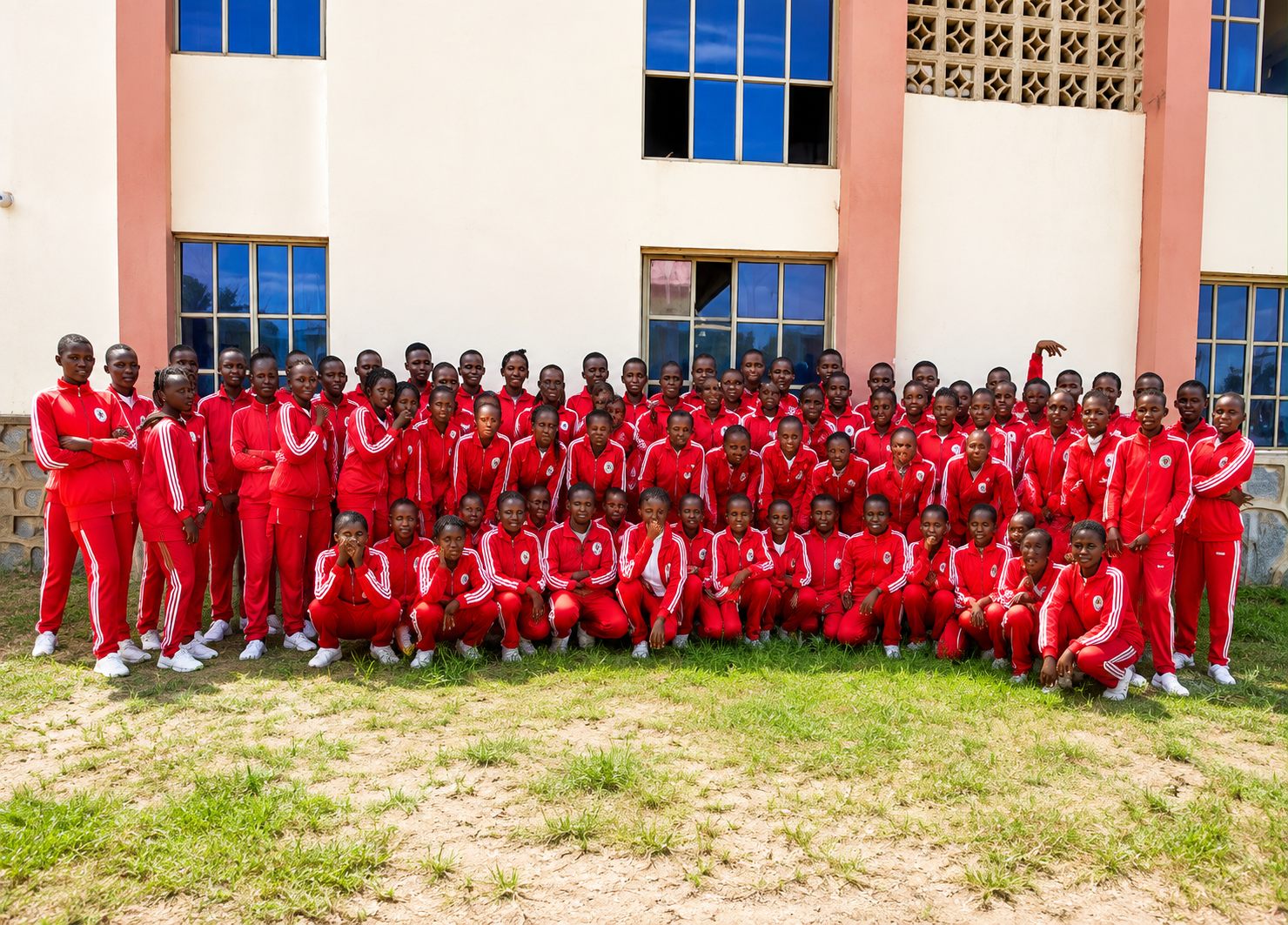 Rishama students in red house uniforms gathered outside the dormitory